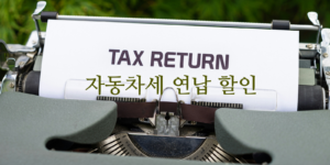 자동차세 연납 고지서를 알리는 타자기로 세금 환급 종이 위에 "TAX RETIRN" 문구가 있음.