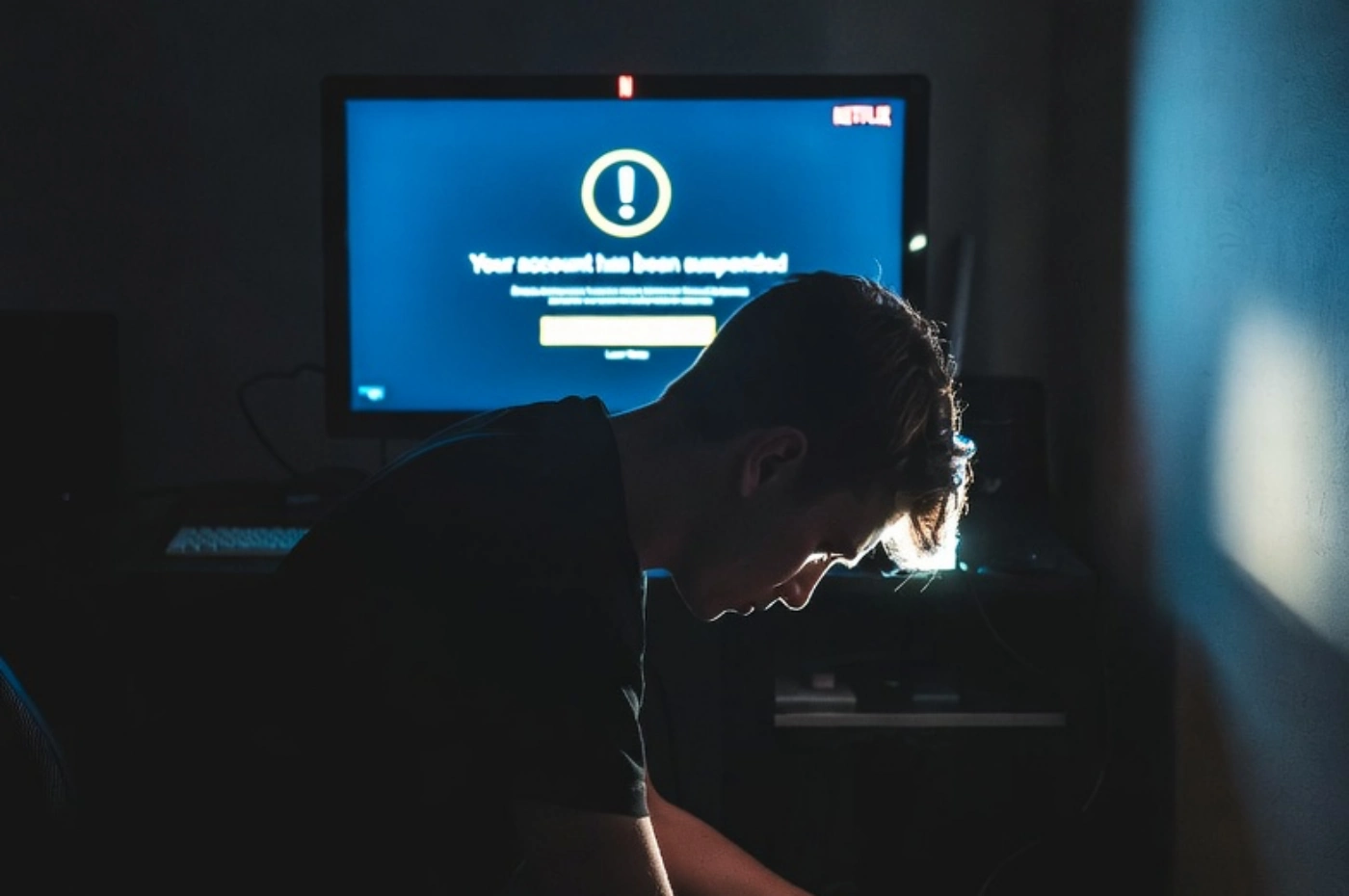 넷플릭스 VPN 우회 결재 실패로 좌절하는 모습입니다. 컴컴한 방 안에서 책상 위 아이맥과 바로 앞 의자에 앉아 남성이 방바닥 아래를 바라고 있습니다.