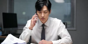 개인회생 추심 전화 대응하는 30대 직장인이 사무실에서 서류를 보면서 확인하고 있다.