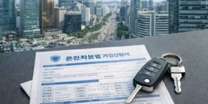 운전자보험 자동차보험 차이점 확인하는데 고층 빌딩 사무실에서 서류와 자동차 키가 보입니다.